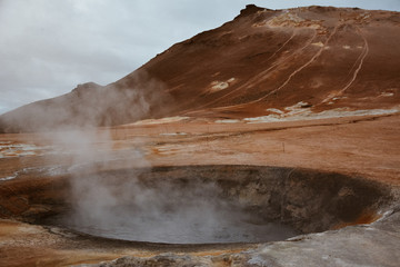 Boiling mudpots in the geothermal area Hverir and cracked ground around, Iceland in summer. Myvatn region, North part of Iceland