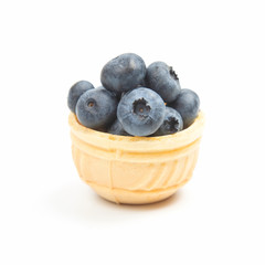 blueberries in a waffle basket on a white background. Vitamins and wholesome foods