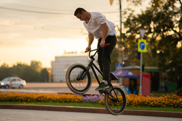 Obraz premium The guy performs a stunt on BMX, jumping high up.