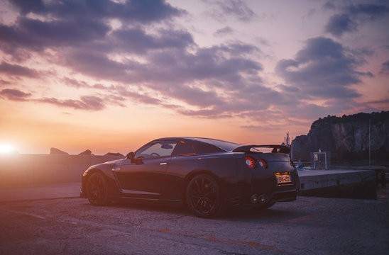 SISTIANA, ITALY JUNE 12, 2013: Photo of a Nissan GT-R Black Edition side view at the sunset. The Nissan GT-R is a 2-door 2+2 sports car produced by Nissan and unveiled in 2007.