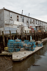 Fototapeta na wymiar Commercial fishing wharf with stacks of lobster traps in the Old Port Harbor district of Portland, Maine. 