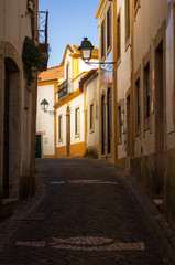 Fototapeta na wymiar Highlighted white and yellow house on a street in the historic center of ConstÃ¢ncia, in Portugal.