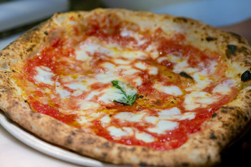 Neapolitan pizza Margherita served in a pizzeria in Napoli, Italy