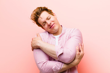 young red head man feeling in love, smiling, cuddling and hugging self, staying single, being...