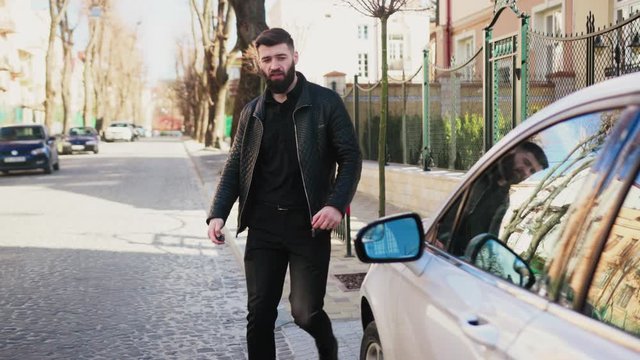 Slow motion young man walk sitting in car on street serious happy sunset vehicle sit arm auto street automobile businessman jacket portrait close up slow motion