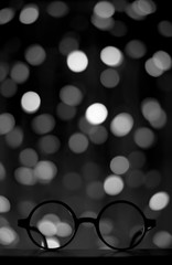 harry potter glasses in dark space with bright lights in the background, copyspace, copy space, wizard themed birthday party invitation