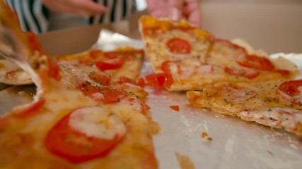 Opening of Box with Takeaway Pizza and Sharing Pizza Slices between Group of People. Lunch Time in Office or Home using Food Delivery Service. 4K Close up Shot