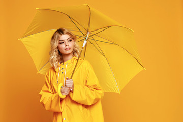 young happy emotional girl laughing  with umbrella   on colored yellow background