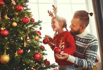 happy family father and child girl decorated Christmas tree
