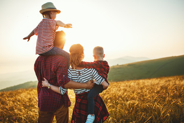 Happy family: mother, father, children son and daughter on sunset.