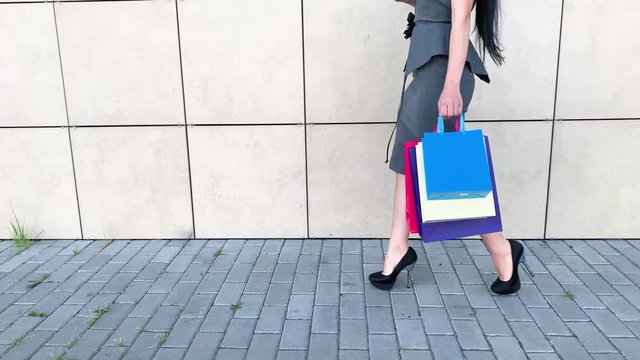 Shopping. Woman holding colored bags near her shooping mall in black friday holiday