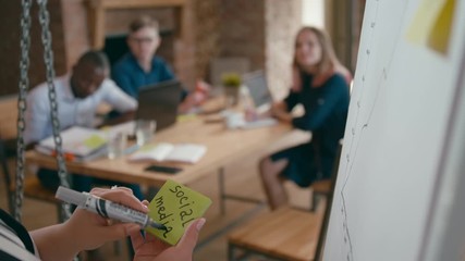 Close Up of Female Hand Writing on Memo Note SOCIAL MEDIA and Sticking it to White Flipchart Board in Office at Team Meeting. 4K Corporate Static Shot