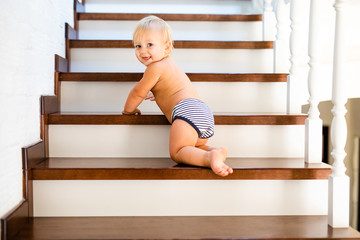 10 months adorable blonde baby development , climbing up stairs at home