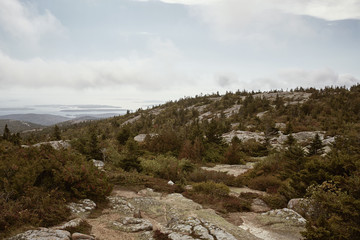 Fototapeta na wymiar Hiking along granite bedrock on the summit of Cadillac Mountain in Acadia National Park on Mount Desert Island, Maine.