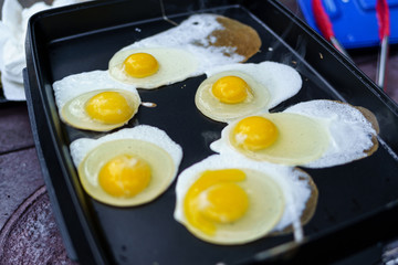 Six eggs cooking on camping griddle