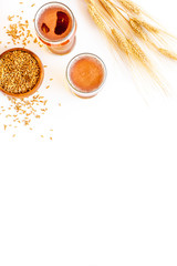 Barley or wheat as beer ingredient near beer glasses on white background top view copy space