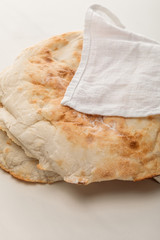 lavash bread covered with towel on white surface