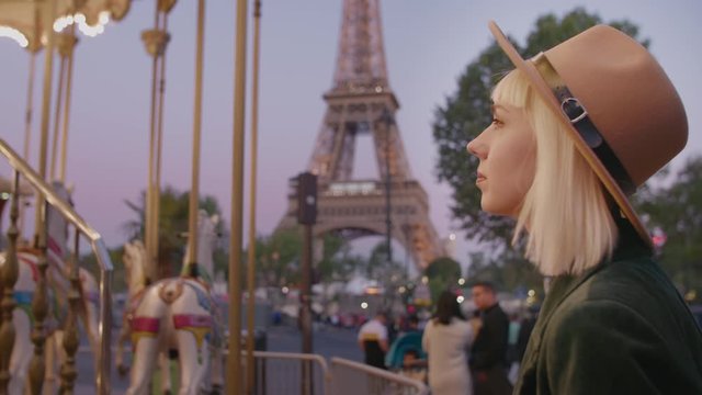 Traveller, tourist girl looking at vintage carousel in Paris near Eiffel tower