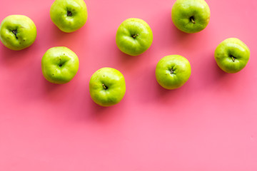 Green apples pattern on pink background top view frame space for text