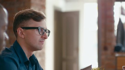 Business Team Eats Lunch Together at Workplace. Diverse Group of Four People Eats Takeaway Pizza and Discusses Project in Loft Office. 4K Gimbal Circling Medium Close up Shot