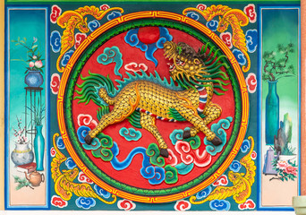 Fototapeta premium Bang Phra, Thailand - March 16, 2019: Chao Pho Khao Chalak Chinese Cemetery. Reunion hall and shrine for mourning families. Outer wall painting of monster liion in vivid colors.