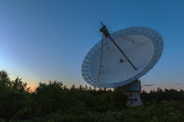 A large radio telescope at dusk 