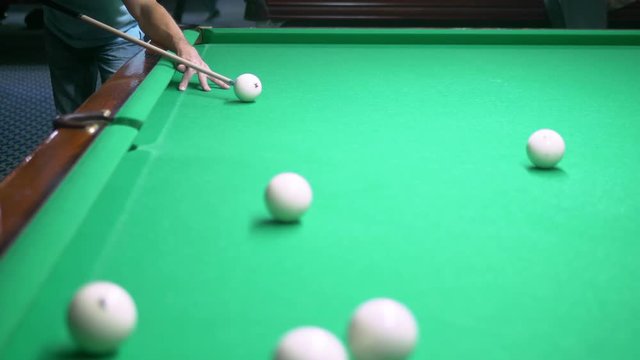 billiards. Close-up. man hand with cue and white ball on a green pool table. copy space