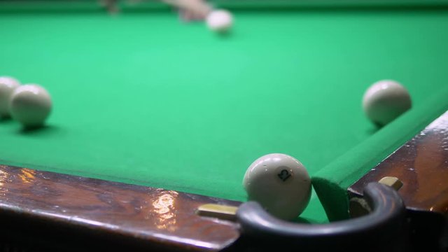 billiards. Close-up. man hand with cue and white ball on a green pool table. copy space