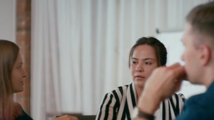 Business Meeting of Multiethnic Group of People. Positive Diverse Creative or Marketing Startup Team is Discussing Project in Loft Office. 4K Medium Orbit Shot