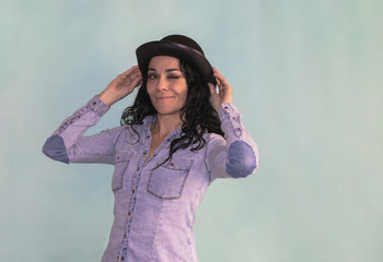 Brunette woman with black hat winking an eye to the camera