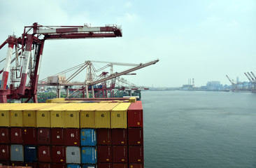 Container terminal in Kaohsiung, Taiwan. Gantry cranes loading containers on the cargo ship. 