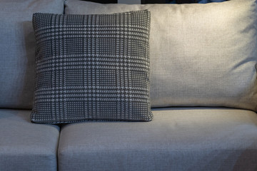 Naklejka na ściany i meble Modern gray fabric pillow and checkered pattern on the cushion gray sofa interior decoration