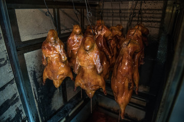 Cooked Beijing grilled duck hanging on restaurant grill