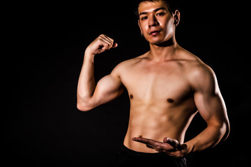 Obraz premium sport man standing showing muscle bodybuilding on black backgrounds, fitness concept, sport concept