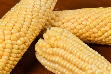 green corn on wooden table without shells
