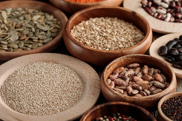 wooden bowls with beans, quinoa, pumpkin seeds and oatmeal