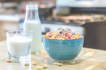 Bowl of colorful children's cereal and milk isolated on wood table with Text space