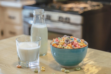 Bowl of colorful children's cereal and milk isolated on wood table with Text space