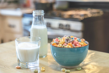 Bowl of colorful children's cereal and milk isolated on wood table with Text space
