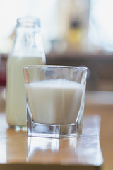 Reptientes with milk on a wooden table and rustic kitchen background. Alternative milk concept. Front view. Horizontal composition