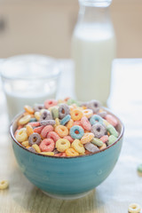 Bowl of colorful children's cereal and milk isolated on wood table with Text space