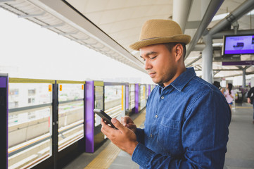 Asian man using smartphone in sky train