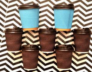 Paper coffee cups on abstract colorful background.