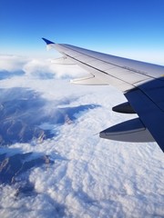 Fototapeta premium wing of airplane flying above clouds