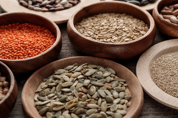 wooden plates and bowls with raw red lentil, pumpkin seeds and oatmeal on table