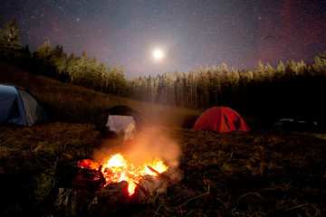 campfire and tent on star night 