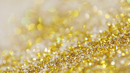 Lights on gold with star bokeh background.Gold celebration background for anniversary, New Year Eve, Christmas, falling coins, wedding or birthday