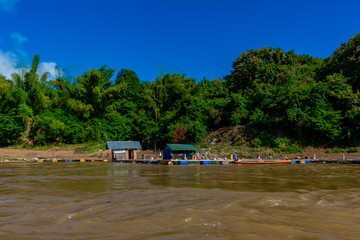Beautiful green hills landscape with boat and rivers on blue sky background. decoration image contain certain grain noise and soft focus.