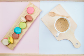 Delicious and colorful macarons placed on a wooden tree decorated with sweet coffee.