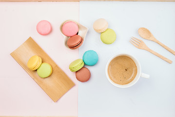 Delicious and colorful macarons placed on a wooden tree decorated with sweet coffee.